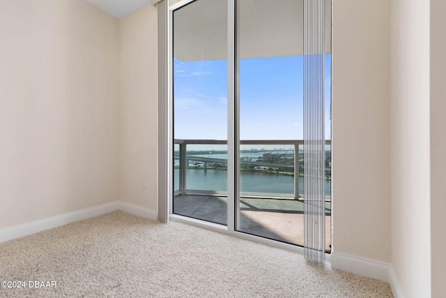 carpeted empty room featuring a water view