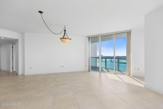 231 Riverside Dr Unit 1209-1, Daytona Beach, FL 32117 - unfurnished room featuring floor to ceiling windows, light tile patterned floors, and baseboards