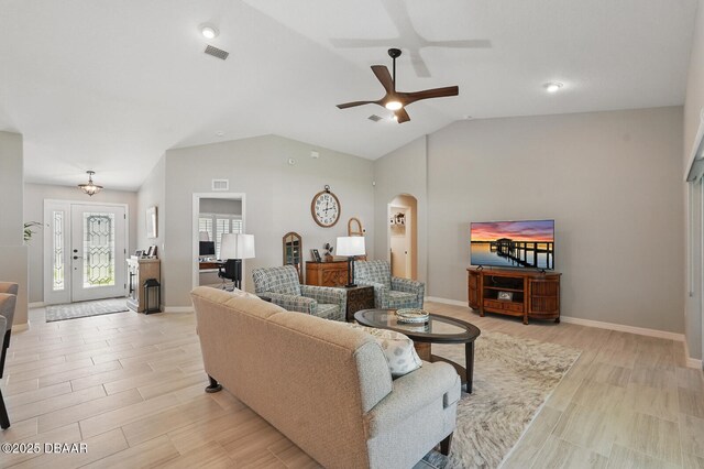 70 Esperanto Dr, Palm Coast, FL 32164 - living area with arched walkways, vaulted ceiling, a ceiling fan, and light wood-style flooring