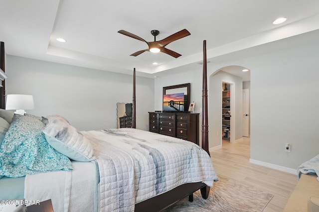 70 Esperanto Dr, Palm Coast, FL 32164 - bedroom featuring arched walkways, light wood-type flooring, a tray ceiling, recessed lighting, and ceiling fan