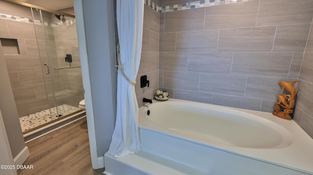 4601 S Atlantic Ave Unit 702, Ponce Inlet, FL 32127 - bathroom featuring wood finished floors, a tile shower, a washtub, and toilet