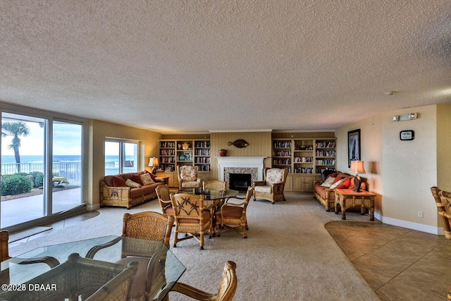 4601 S Atlantic Ave Unit 702, Ponce Inlet, FL 32127 - carpeted living area featuring baseboards, a textured ceiling, and a fireplace