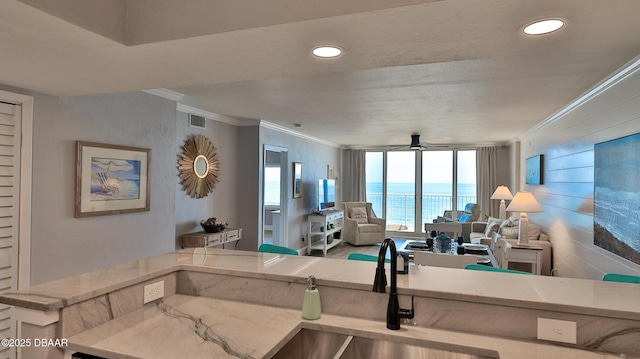 4601 S Atlantic Ave Unit 702, Ponce Inlet, FL 32127 - kitchen with crown molding, visible vents, light stone countertops, ceiling fan, and a sink
