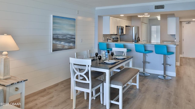 4601 S Atlantic Ave Unit 702, Ponce Inlet, FL 32127 - dining room featuring ornamental molding, light wood-style flooring, and visible vents