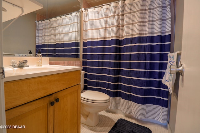 bathroom with toilet, vanity, and tile patterned floors