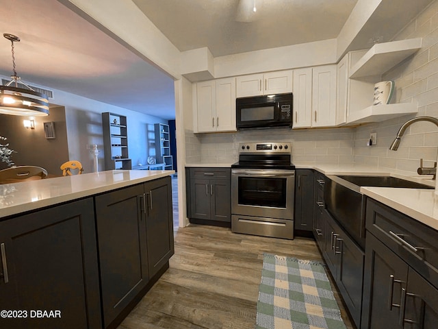 kitchen with white cabinets, decorative backsplash, stainless steel range with electric stovetop, light hardwood / wood-style flooring, and decorative light fixtures