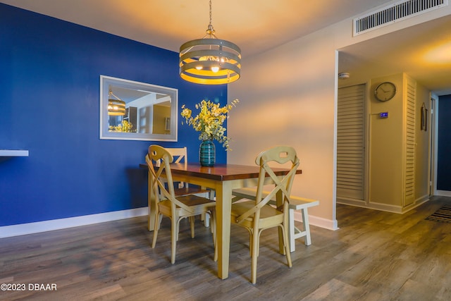 dining area with hardwood / wood-style flooring and a notable chandelier