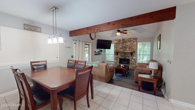 167 Fox Glen Ct, Ormond Beach, FL 32174 - dining space with ceiling fan, a stone fireplace, light tile patterned floors, and vaulted ceiling with beams
