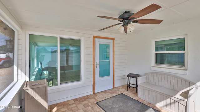 entrance to property with ceiling fan and a patio area