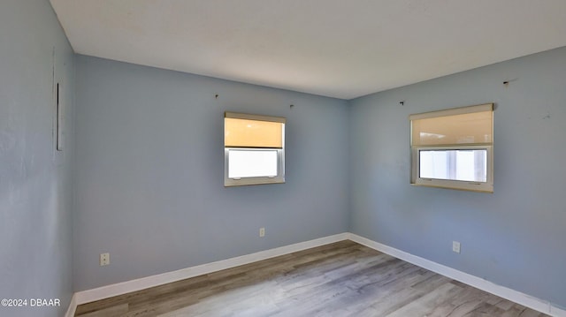 unfurnished room with baseboards and wood finished floors