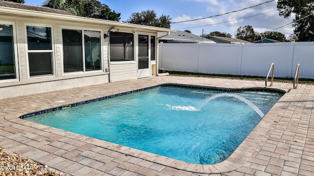 view of swimming pool with a sunroom and a patio area