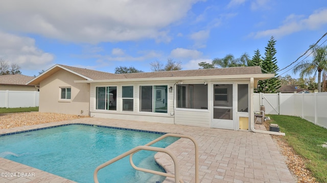 rear view of house featuring a fenced in pool, a fenced backyard, roof with shingles, a patio area, and stucco siding