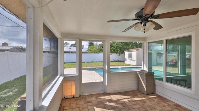 unfurnished sunroom featuring ceiling fan and plenty of natural light