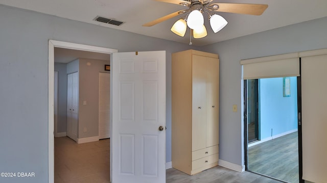 unfurnished bedroom featuring light wood-type flooring, baseboards, visible vents, and ceiling fan