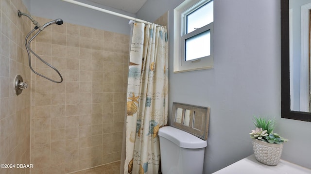 bathroom with a tile shower and toilet