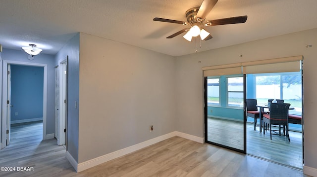 unfurnished room with a ceiling fan, a textured ceiling, baseboards, and light wood finished floors