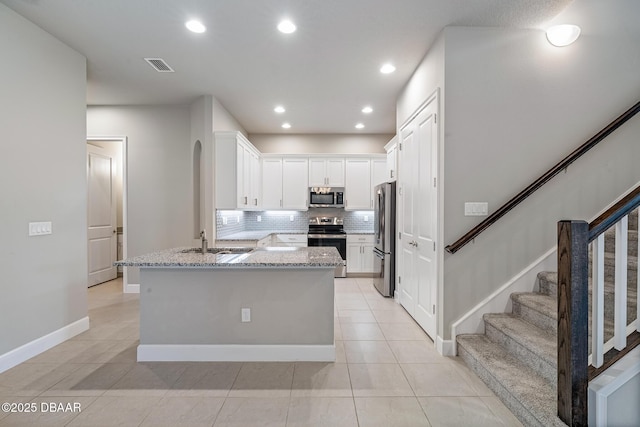 136 Longridge Ln, Ormond Beach, FL 32174 - kitchen featuring appliances with stainless steel finishes, a sink, light stone counters, backsplash, and light tile patterned floors