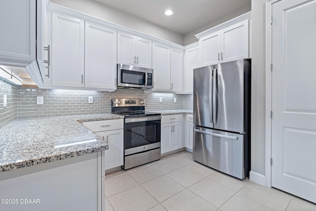 136 Longridge Ln, Ormond Beach, FL 32174 - kitchen featuring stainless steel appliances, light tile patterned floors, white cabinetry, tasteful backsplash, and recessed lighting