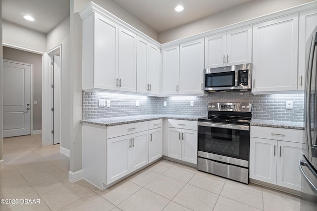 136 Longridge Ln, Ormond Beach, FL 32174 - kitchen with stainless steel appliances, white cabinetry, light tile patterned floors, and recessed lighting