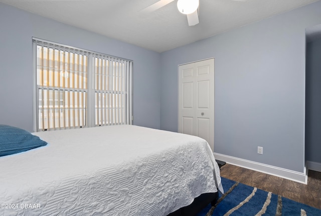 bedroom featuring dark hardwood / wood-style flooring, a closet, and ceiling fan