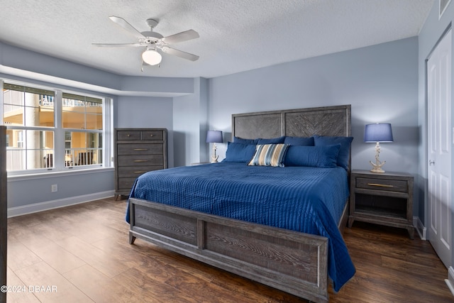 bedroom with a textured ceiling, ceiling fan, a closet, and dark hardwood / wood-style floors