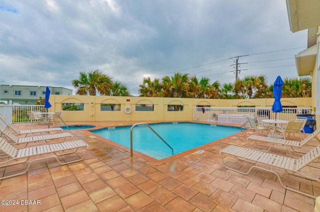 view of pool featuring a patio area and a hot tub