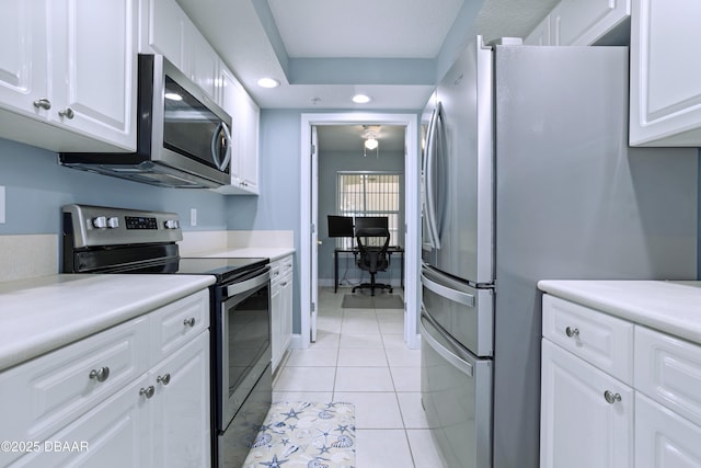 kitchen with appliances with stainless steel finishes, white cabinetry, and light tile patterned flooring