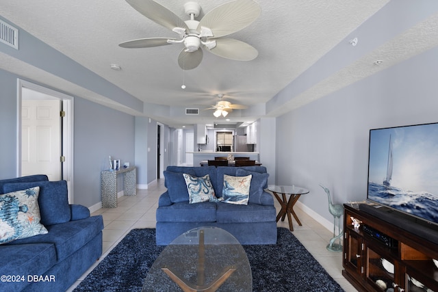 tiled living room featuring ceiling fan and a textured ceiling