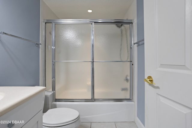 full bathroom with tile patterned flooring, vanity, bath / shower combo with glass door, and toilet