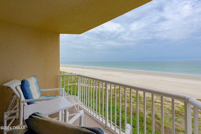 balcony featuring a beach view and a water view