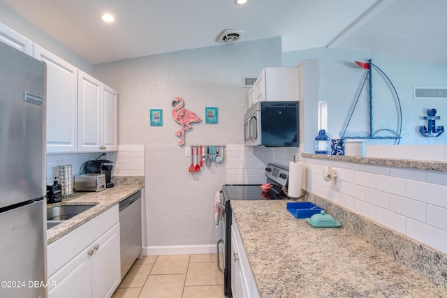 kitchen with white cabinetry, sink, light stone counters, light tile patterned floors, and appliances with stainless steel finishes