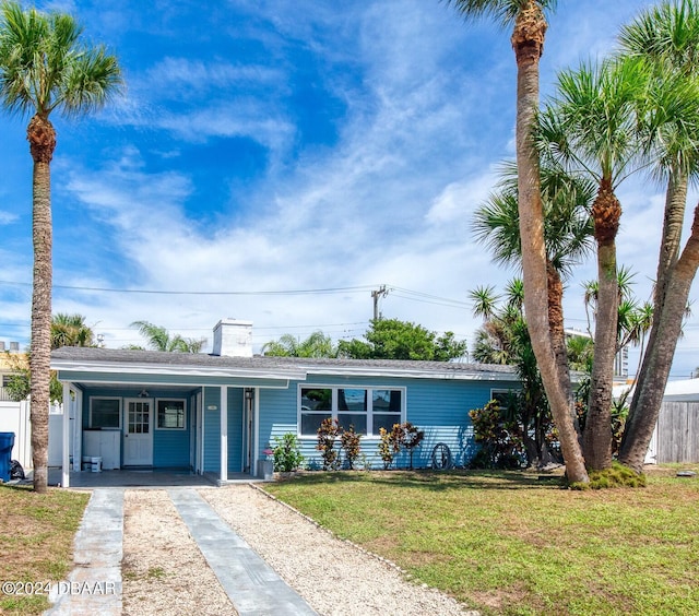 single story home featuring a front lawn and a carport