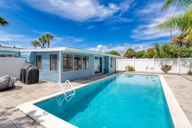 view of pool with a grill and a patio area