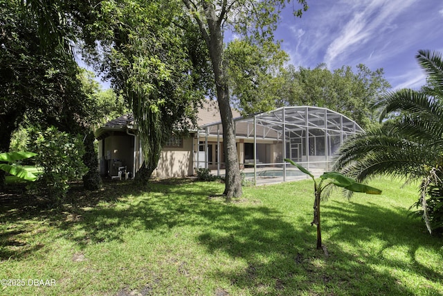 3 Indian Springs Dr, Ormond Beach, FL 32174 - back of property featuring a yard, an outdoor pool, stucco siding, and glass enclosure