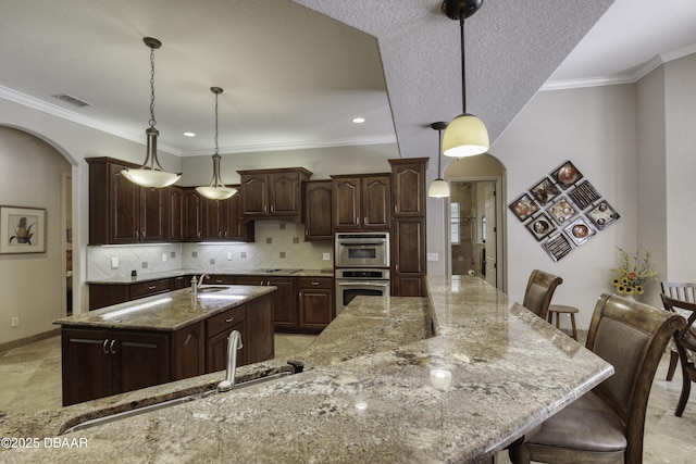 3 Indian Springs Dr, Ormond Beach, FL 32174 - kitchen with arched walkways, a large island, light stone countertops, double oven, and decorative backsplash