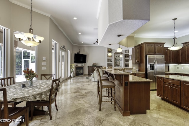 3 Indian Springs Dr, Ormond Beach, FL 32174 - kitchen with stainless steel fridge with ice dispenser, decorative backsplash, crown molding, light stone countertops, and a breakfast bar area