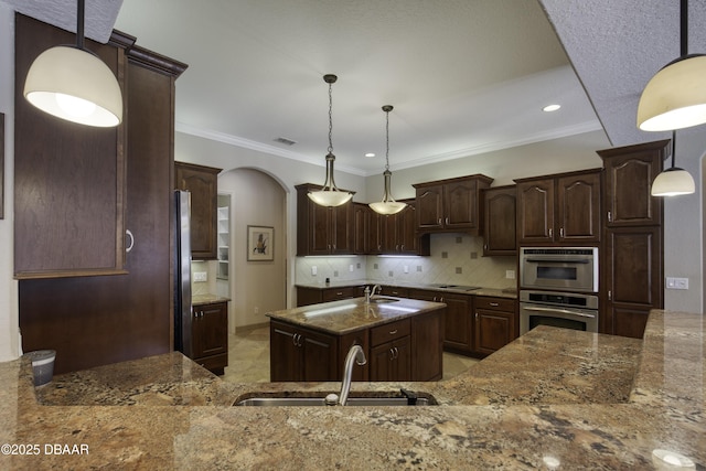 3 Indian Springs Dr, Ormond Beach, FL 32174 - kitchen featuring arched walkways, stone counters, ornamental molding, decorative backsplash, and dark brown cabinets