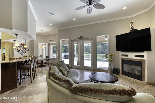 3 Indian Springs Dr, Ormond Beach, FL 32174 - living area featuring ornamental molding, a ceiling fan, a tiled fireplace, recessed lighting, and french doors
