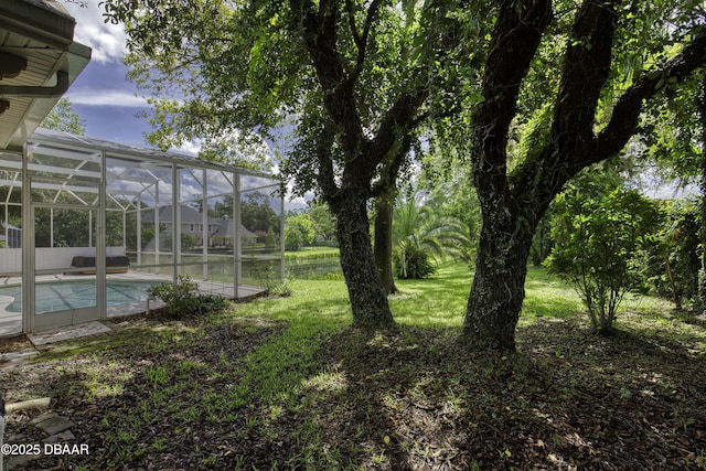 3 Indian Springs Dr, Ormond Beach, FL 32174 - view of grassy yard featuring an outdoor pool, glass enclosure, and a water view