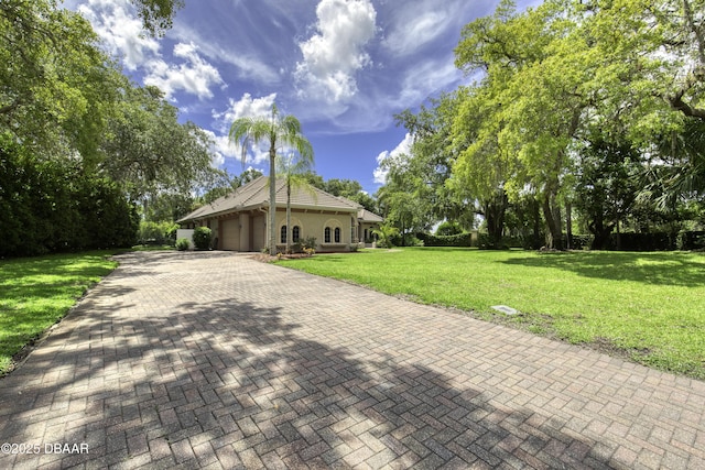 3 Indian Springs Dr, Ormond Beach, FL 32174 - view of front of property with an attached garage, a front yard, decorative driveway, and stucco siding