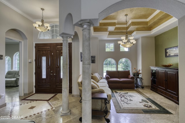 3 Indian Springs Dr, Ormond Beach, FL 32174 - foyer entrance featuring a chandelier, ornamental molding, arched walkways, inlaid floor details, and ornate columns