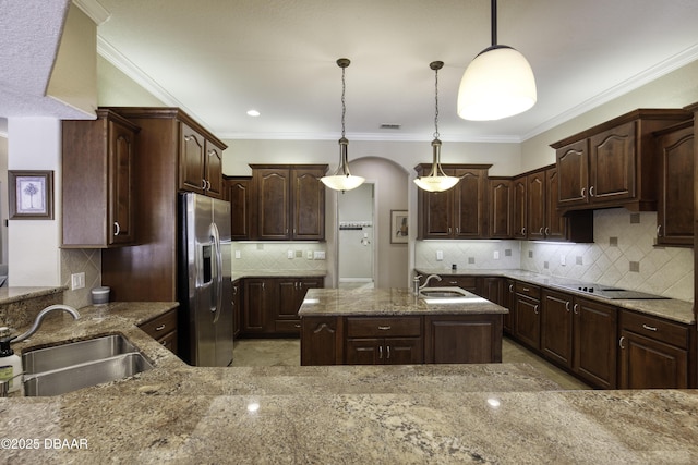 3 Indian Springs Dr, Ormond Beach, FL 32174 - kitchen featuring stainless steel fridge with ice dispenser, black electric cooktop, tasteful backsplash, light stone countertops, and arched walkways