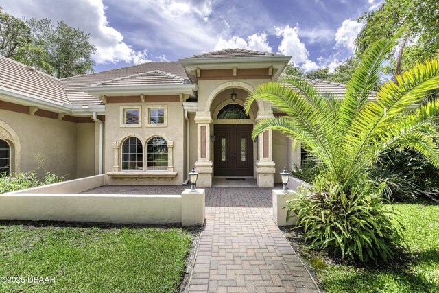 3 Indian Springs Dr, Ormond Beach, FL 32174 - entrance to property with french doors, stucco siding, and a tiled roof