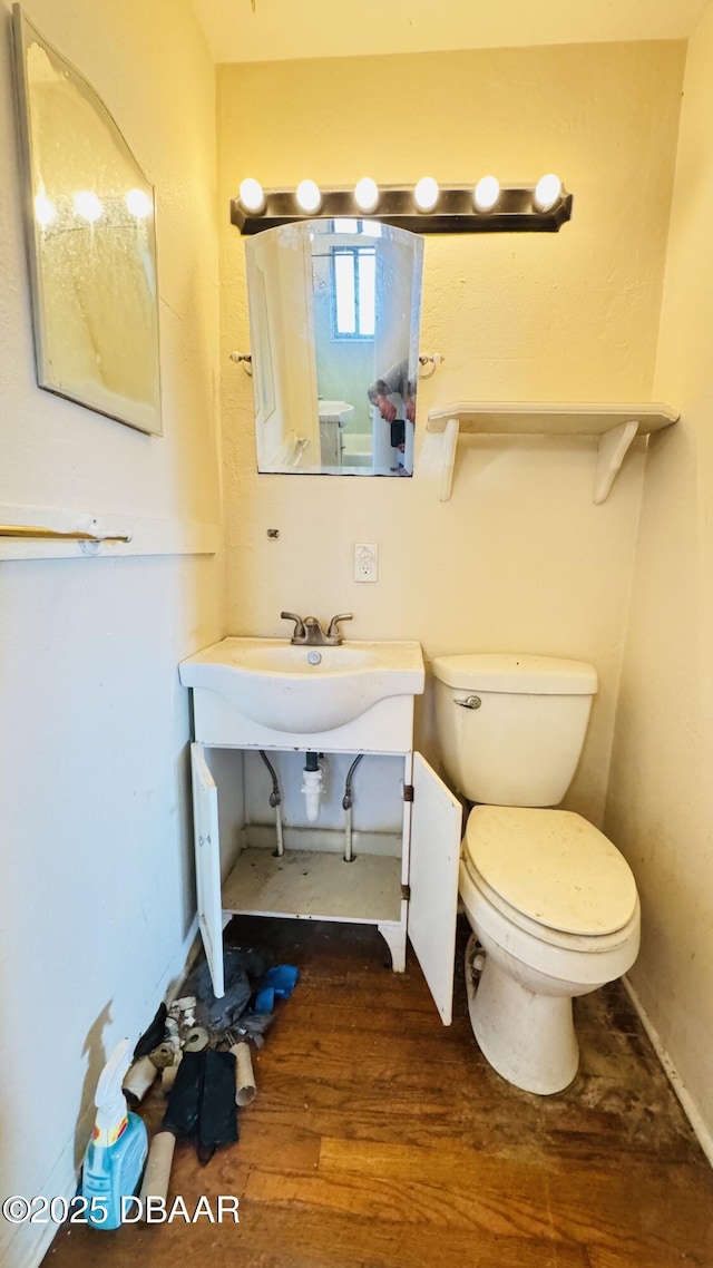 bathroom with toilet and wood finished floors