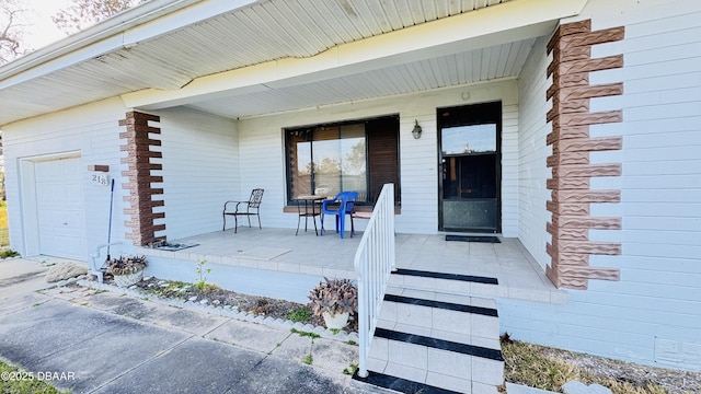 property entrance with an attached garage and covered porch