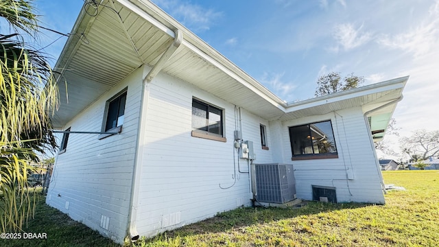 view of side of property with crawl space, a lawn, and central air condition unit