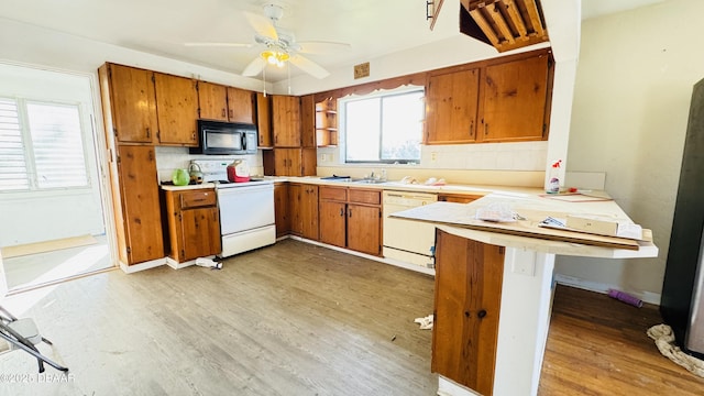 kitchen featuring a peninsula, white appliances, open shelves, and brown cabinets