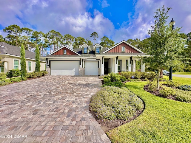 craftsman-style house with a garage, covered porch, and a front yard