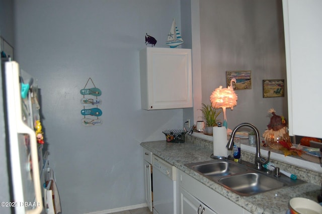 kitchen featuring dishwasher, fridge, white cabinetry, and sink