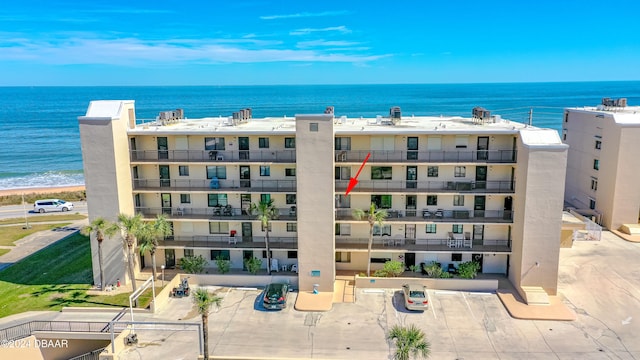 view of building exterior with a water view and a view of the beach